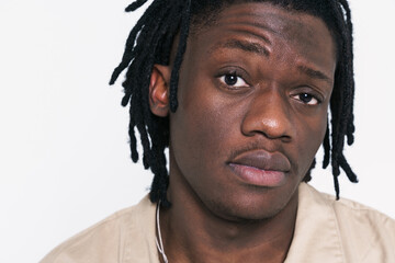 Young black man with dreadlocks posing and looking at camera