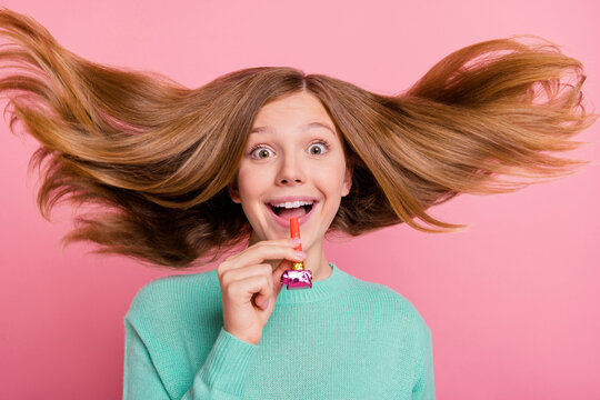 Photo of funky charming girl wear turquoise sweater air blowing whistle isolated pink color background