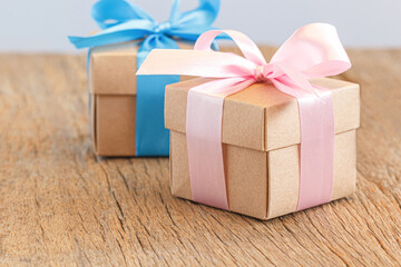 Gift box with ribbon bow on brown wood background