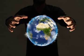 Hand holding earth on dark light background , Elements of image are furnished by NASA