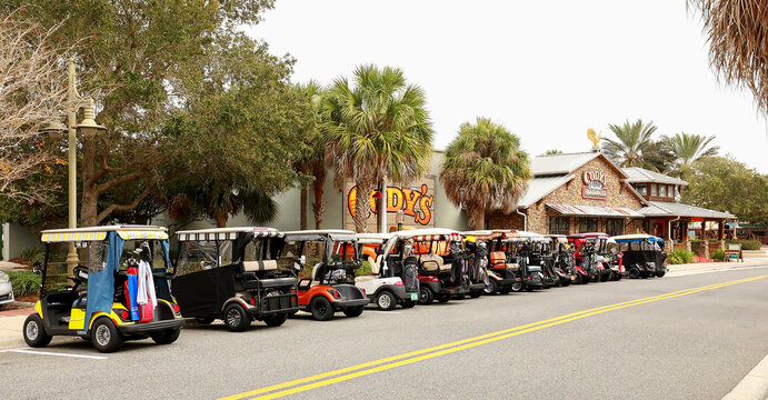 Golf carts parked in front of a local restaurant in The Villages..  The Villages is an active adult retirement community in Sumter County, Florida, USA. 