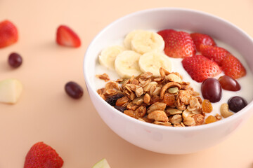 bowl of granola cereal with yogurt and berries isolated on eggnog color background