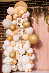 baby shower party. festive area decorated different color, gold, white and pink of balloons, pink cloth, light and greenery. Decoration photo zone. Festive decorative elements, photo area