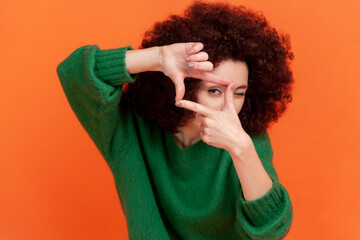 Young adult woman with Afro hairstyle wearing green casual style sweater standing crop composition...