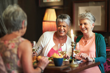 Wining, dining and reminiscing. Cropped shot of a group of senior female friends enjoying a lunch...