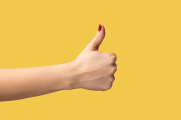 Profile side view closeup of woman hand showing like or thumbs up, approved, positive feedback....