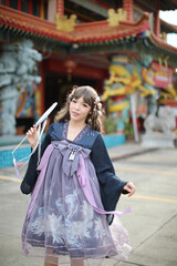 Obraz premium Beautiful young woman with dark blue Chinese lolita dress with Chinese garden