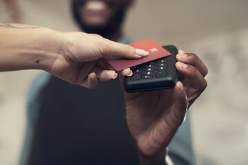 Paying just got easier in our store. Shot of an unrecognizable man standing in his bicycle shop and assisting a customer with her purchase.