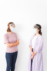 フェイスシールドをして話す若い女性