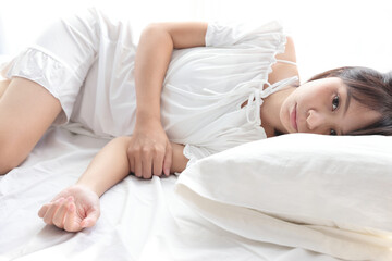 Fototapeta na wymiar Beautiful young woman legs sleeping in the morning at white bedroom