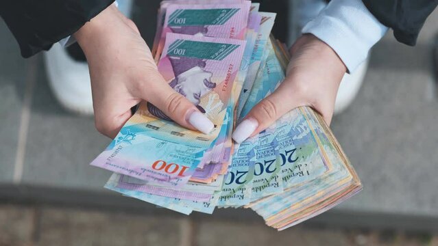 A girl counts old Venezuelan money.