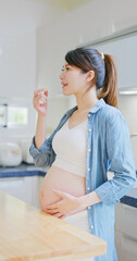 Asian pregnant woman take vitamin