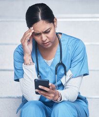 Looks like Im booked for another shift. Shot of a female nurse looking upset while using her...