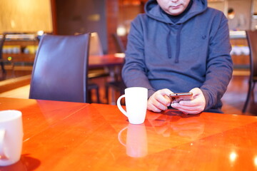 Man using smartphone at cafe, texting on his mobile phone - スマートフォン 操作する男性	 - obrazy, fototapety, plakaty
