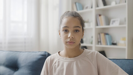 Lonely female teenager looking at camera, family separation, negative emotions