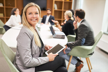Junge Geschäftsfrau im Meeting mit Tablet Computer