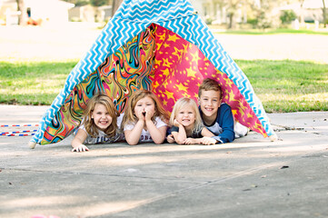 four kids in tent outside