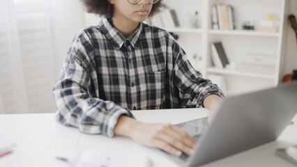 Fototapeta premium Female pupil searching information online, sitting at table, distance education