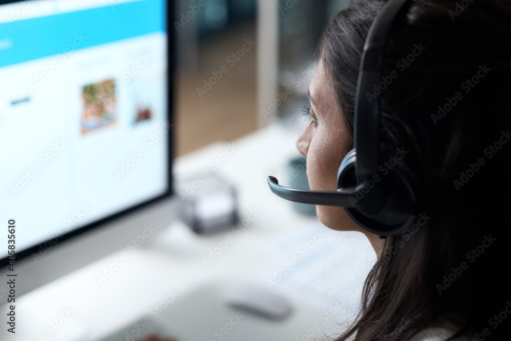 Poster fully skilled in providing quality customer support. shot of a young woman using a headset and compu