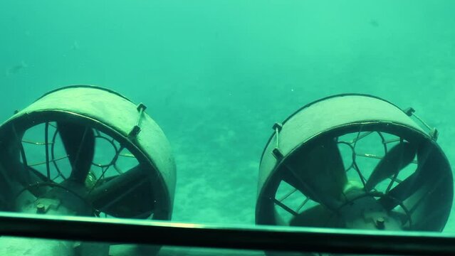 Submarine propellers work in the sea with fishes