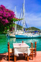 Poster Traditional Greek restaurants (taverns) by the sea. Sivota fishing village in Lefkada island. Greece, Ionian islands © Freesurf