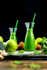 Healthy green smoothies with spinach, apple, kiwi, broccoli and mint in glass jar with fruits and vegetables on the wooden table. Detox and healthy concept