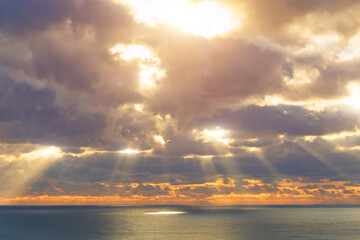 Rays divine holy from the sun behind the clouds break through and illuminate the surface of the...