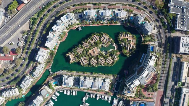 Aerial top down shot of the marina island located in Cape Town's Waterfront. The drone flies upward and more of the scene is revealed by a swift speed ramp.