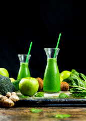 Healthy green smoothies with spinach, apple, kiwi, broccoli and mint in glass jar with fruits and vegetables on the wooden table. Detox and healthy concept