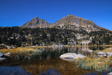 Las montañas se reflejan en un bonito lago en los Pirineos Andorranos