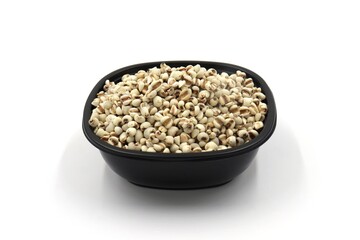 dried millet in a black plastic bowl on white background