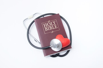 Holi bible and red heart with medical stethoscope. Soul healing, mental health and healing concept