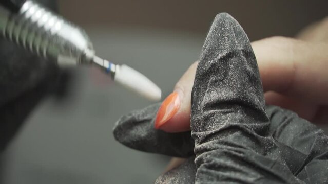 manicurist works with a drill with male nails