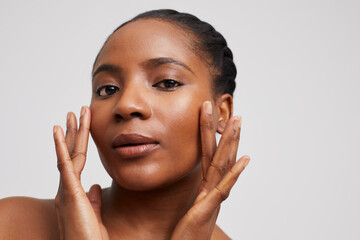 Studio portrait of woman touching face