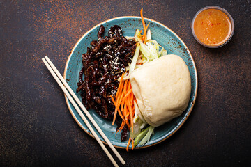 Chinese traditional dish sweet and sour deep fried glazed pork with vegetables and steamed bao bun...