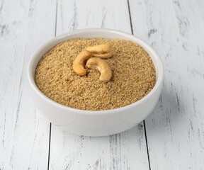 Cashew nut flour in a bowl over wooden table. Gluten free flour