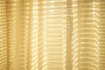 Sunny organza tulle with golden sunlight and blinds shadows
