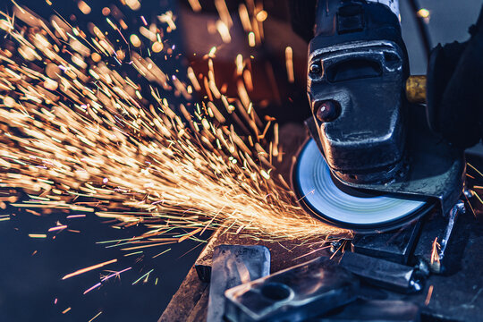 Electric wheel grinding on metal details in factory. Metallurgical Plant 