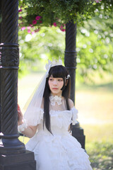 A beautiful woman in lolita dress in garden background Japanese street fashion portrait