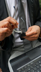 Midsection of business man cleaning eyeglasses