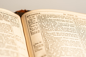 Close up of detail of John 19:18 (KJV) from an old Bible with shallow depth of field