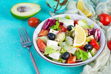Fresh salad with tomato, lettuce, avocado, olives, feta and pepper. Diet eating