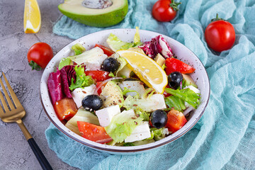 Fresh salad with tomato, lettuce, avocado, olives, feta and pepper. Diet eating