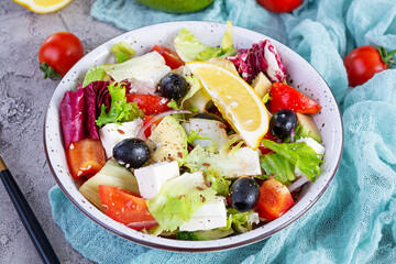 Fresh salad with tomato, lettuce, avocado, olives, feta and pepper. Diet eating