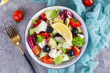 Fresh salad with tomato, lettuce, avocado, olives, feta and pepper. Diet eating
