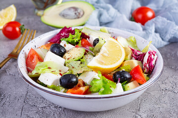 Fresh salad with tomato, lettuce, avocado, olives, feta and pepper. Diet eating