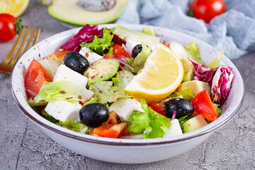 Fresh salad with tomato, lettuce, avocado, olives, feta and pepper. Diet eating