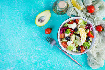 Fresh salad with tomato, lettuce, avocado, olives, feta and pepper. Diet eating