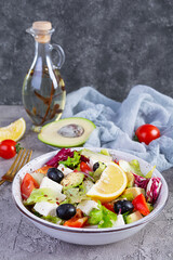 Fresh salad with tomato, lettuce, avocado, olives, feta and pepper. Diet eating