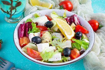 Fresh salad with tomato, lettuce, avocado, olives, feta and pepper. Diet eating